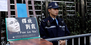 Polizist neben Stuhl mit Foto von Liu Xia