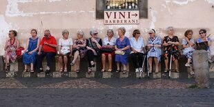 Rentner*innen sitzen auf einer Bank nebeneinander