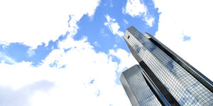 Die Glastürme der Deutschen Bank von unten aufgenommen, sie ragen gegen einen bewölkten Himmel von rechts unten ins Bild