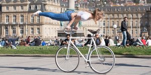 Eine Frau macht eine Kunstfigur auf einem Fahrrad