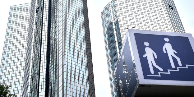 Ein Schild vor dem Gebäude der Deutschen Bank weist auf eine Fußgängerunterführung hin