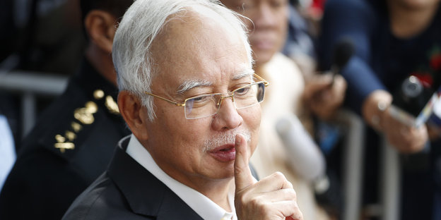 Expremier Najib Razak mit einem erhobenen Zeigefinger vor seinem Mund