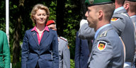 In der linken Bildhälfte eine Frau in Anzug, in der rechten Bildhälfte ein Soldat in Uniform