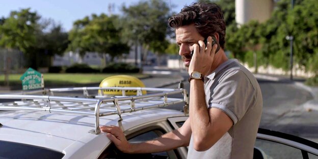 Ben Raphael (Ishai Golan) steht an einem Taxi und telefoniert