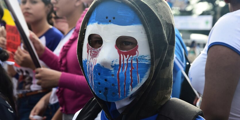 Mensch mit blau weiß angemaltem Gesicht