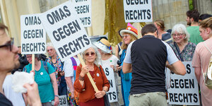 Ältere Gegendemonstrantinnen halten Schilder hoch: „Omas gegen rechts“