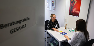 Zwei Frauen sitzen an einem Tisch in einem Raum der Hamburger Gesundheitsbehörde.