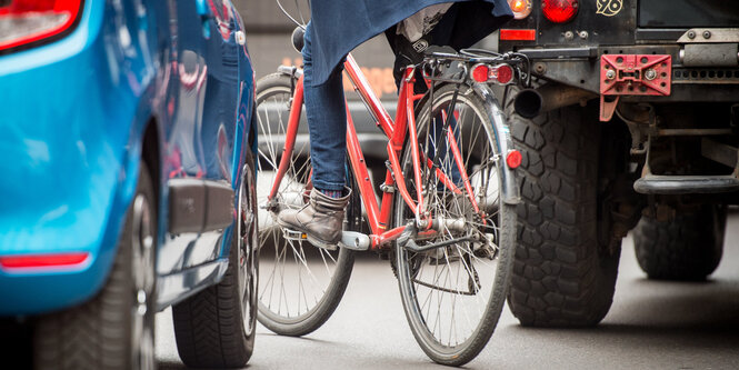 Ein Fahrrad schlängelt sich durch zwei Autos hindurch