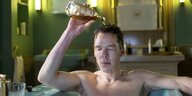 Patrick Melrose (Benedict Cumberbatch) sitzt in der Badewanne und gießt sich Schnaps über den Kopf.