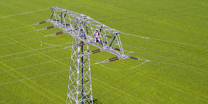 Strommast auf grünem Acker