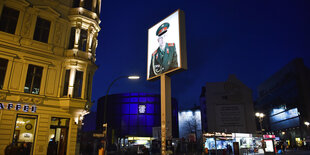 Blick auf das Panorama "Die Mauer" von Yadegar Asisi am ehemaligen Grenzübergang "Checkpoint Charlie" in der Friedrichstraße in den Abendstunden