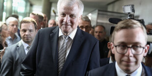 Horst Seehofer umringt von weiteren Personen schreitet auf die Kamera zu