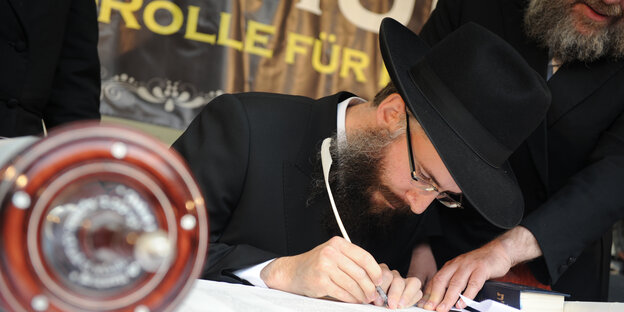 Ein Rabbiner schreibt in eine Tora-Rolle Ein Rabbiner schreibt in eine Tora-Rolle