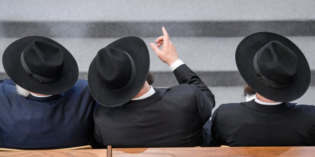 Drei Rabbiner sitzen in der Jüdischen Synagoge in Hamburg