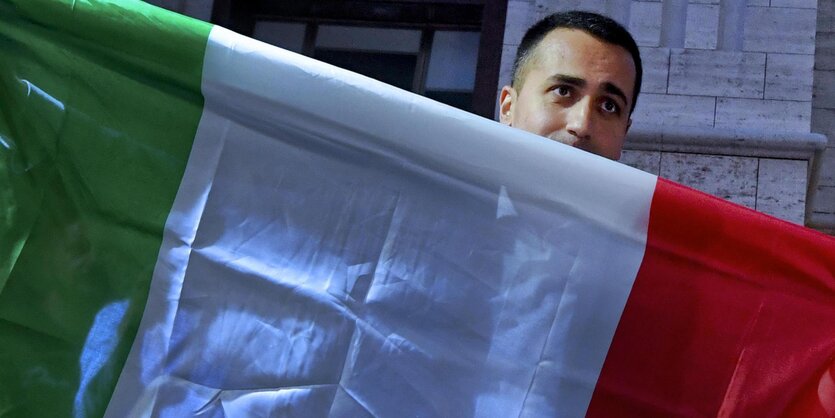 Luigi di Maio schaut hinter einer Italienflagge hervor