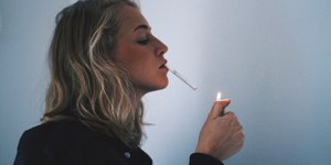 Eine Frau im Profil, die kurz davor ist, sich eine Zigarette anzuzünden