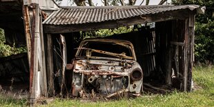 Ein rostendes Auto in einer rostenden Garage