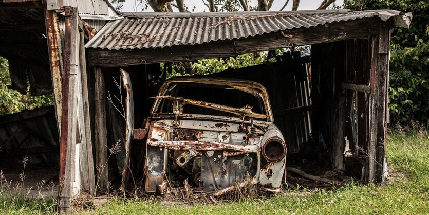 Ein rostendes Auto in einer rostenden Garage