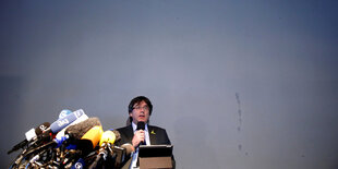 Puigdemont spricht auf einer Pressekonferenz in Mikrofone