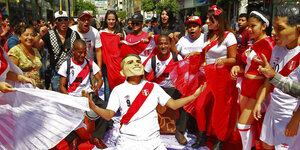 Fans stehen um jemanden mit einer Guerrero-Maske herum