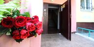 Ein Bund Rosen an einem Pfeiler am Eingang eines Hauses. Die Haustür steht offen