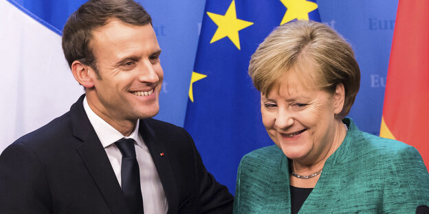 ngela Merkel und Frankreichs Präsident Emmanuel Macron geben sich bei einem EU-Gipfel nach einer Pressekonferenz die Hand