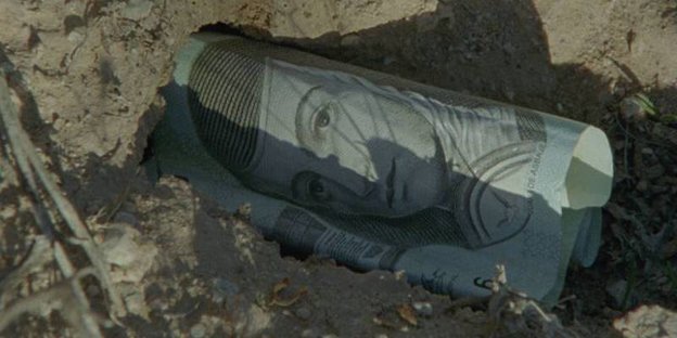 Ein Mitschnitt aus dem Dokumentarfilm „El mar la mar“ zeigt einen Geldschein im Sand