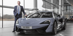 McLaren-Geschäftsführer Mike Flewitt steht neben einem seiner Autos