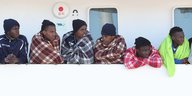 Flüchtlinge sind auf einem Schiff vor Italien in Decken gehüllt