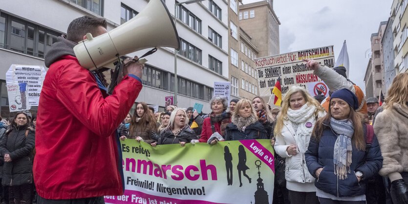 Spitze eines Demonstrationszuges, im Vordergrund ein Mann mit Megafon