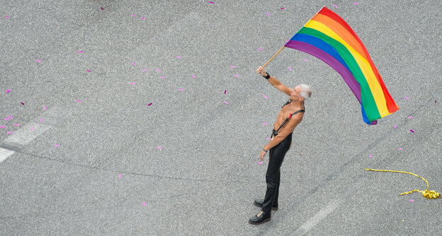 Ein Mann mit Regenbogenfahne