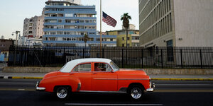 Ein Auto aus den 50er Jahren fährt an dem Gebäude der US-Botschaft in Kuba vorbei.