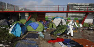 Ein Mitarbeiter der Stadt Paris zieht bei der Räumung eines Migranten-Zeltlagers ein Zelt hinter sich her