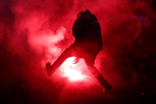 Ein Demonstrant zündet eine Rauchbombe als Protest gegen den G7-Gipfel