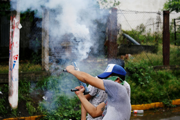 Demonstrant bei Protest in Nicaragua mit selbstgebauter Rauchbombe