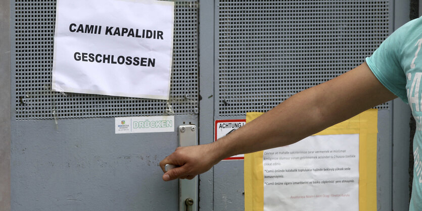 Ein Mann drückt die Klinke einer verschlossenen Tür. Daran hängt ein Schild: "geschlossen"