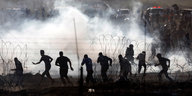 Palästineser vor dem Grenzzaun in Tränengasschwaden