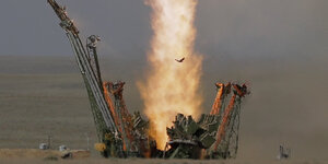 Feuerstrahl eines Raketenstarts, Teile eines Stützgerüsts fallen zur Seite