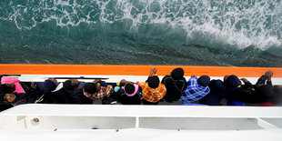 Geflüchtete stehen an Bord der Aquarius und blicken aufs Meer