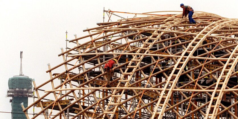 Zwei Menschen arbeiten an einer Holz-Konstruktion