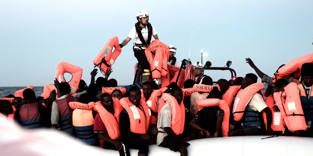 Im Mittelmeer gerettete Flüchtlinge sitzen an Bord der Aquarius unter einer Plane