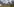Luftfoto eines Stück brennenden Regenwalds, am Rand grasen Kühe