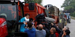 Christine Lambert vom Bauernverband in Frankreich steht auf einem Traktor, der eine Straße versprerrt