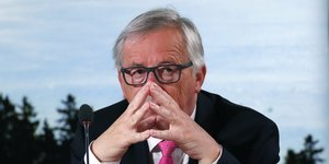Jean-Claude Juncker hat die Hände vor dem Gesicht