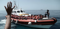 Flüchtlinge, ausgestattet mit Schwimmwesten, sitzen in einem Boot der italienischen Küstenwache
