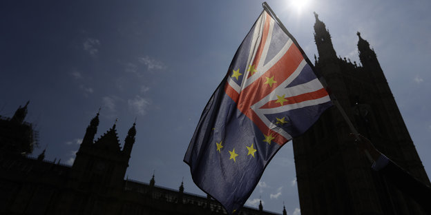 Eine Fahne, die zur Hälfte aus der britischen und zur Hälfte aus der Europaflagge besteht vor dem britischen Parlament