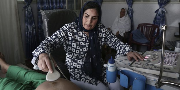 Frau mit Koptuch hilft Patienten
