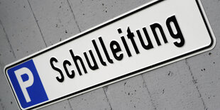 Ein Parkplatzschild auf dem Schulleitung steht