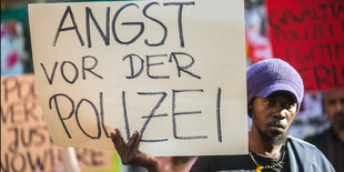 Ein Mann hält ein Schild mit der Aufschrift "Angst vor der Polizei"