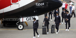 Ägytische Nationalspieler vor einem Fluzeug